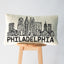 Cream colored hook pillow with black Philadelphia skyline and 'PHILADELPHIA' text displayed on wooden stool