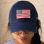 Person wearing a navy blue hat with an american flag on it