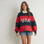 Woman wearing navy and red striped rugby-style collared top with USA text, paired with denim shorts