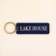 Navy blue rectangle keychain with gold ring and white LAKE HOUSE text on cream background