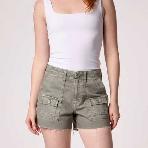 Woman wearing white sleeveless tank top and khaki cargo shorts with front patch pockets and distressed hem