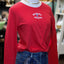 Red long-sleeve Philadelphia Phillies tee with white arch logo and blue P symbol, styled with dark jeans and gold chain neck…