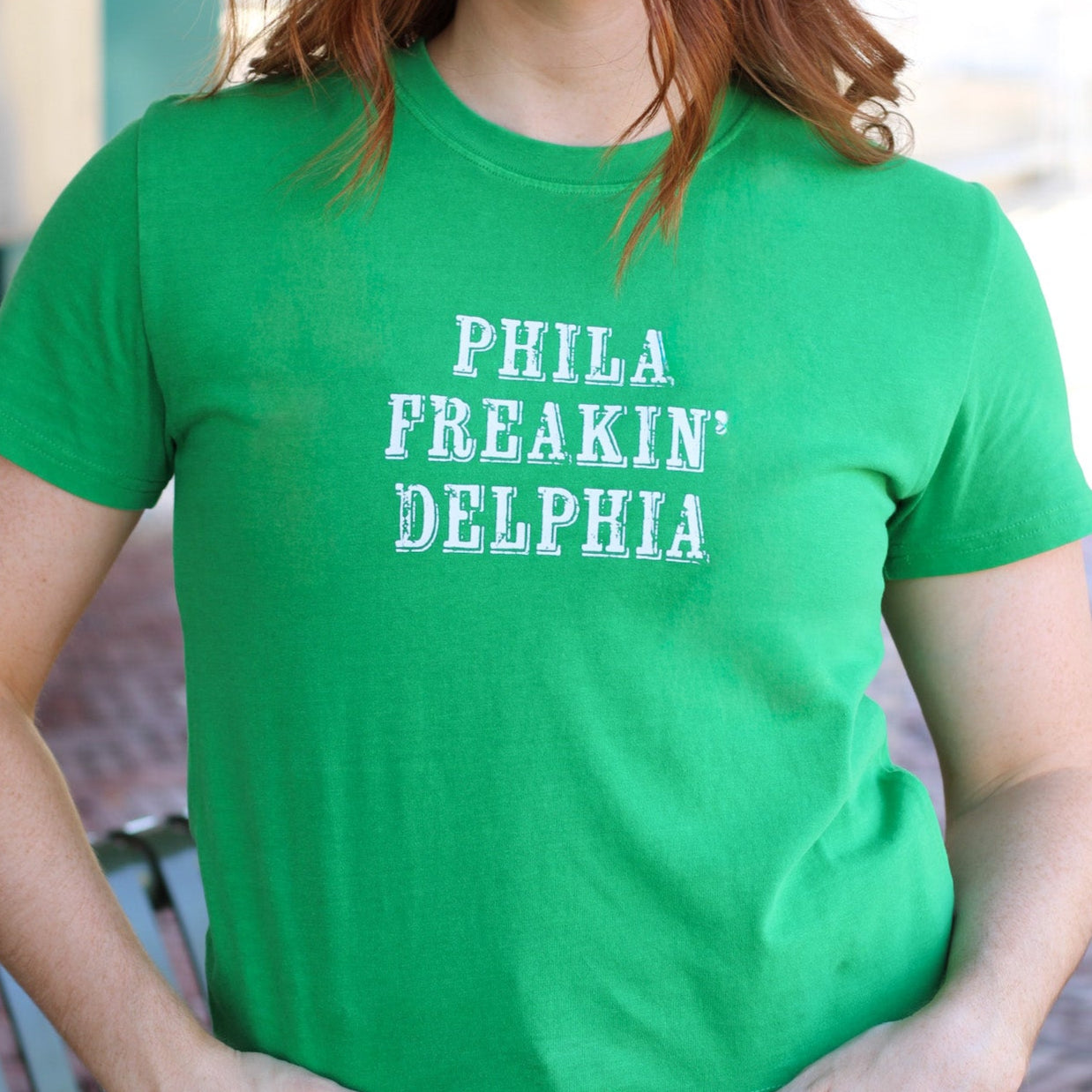 Woman wearing bright green cotton t-shirt with white text reading 'PHILA FREAKIN' DELPHIA' Main image