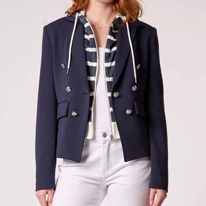 Navy hooded blazer with double-breasted silver buttons, worn open over striped shirt and white pants