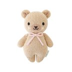Knitted teddy bear with a pink bow on a white background