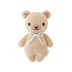 Knitted teddy bear with a blue bow on a white background