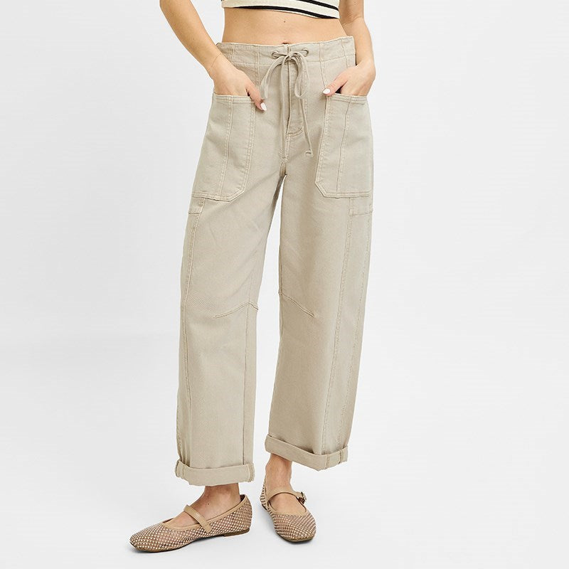 Woman wearing cream cargo pocket jeans with rolled cuffs and a striped crop top, styled with beige woven loafers