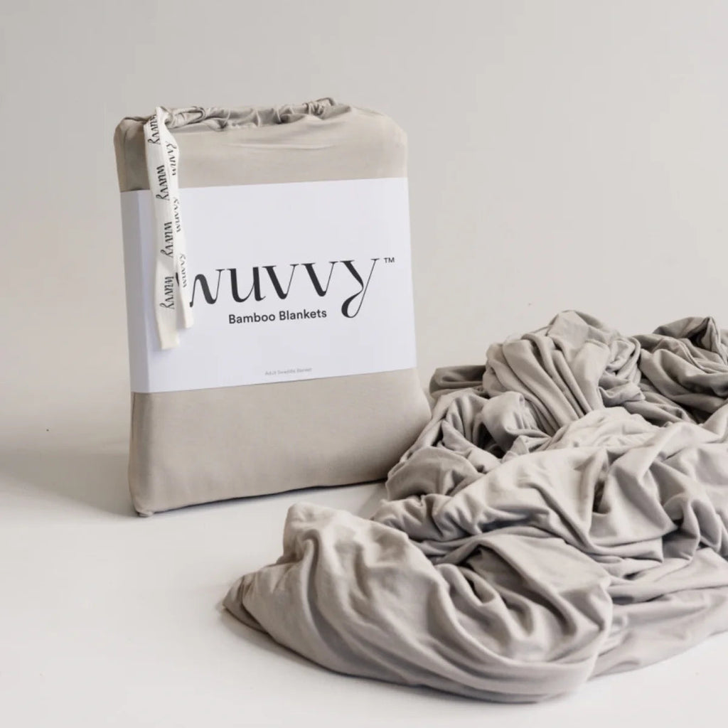 Wuvvy small bamboo blanket in cream, packaged in branded box with fabric bundle displayed beside packaging