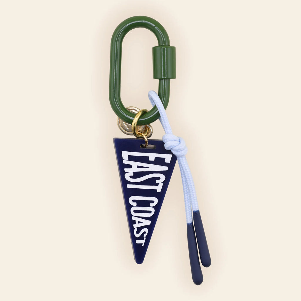 Navy East Coast pennant bag charm with white text, green carabiner, and light blue tassel attached to brass ring