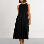 Woman wearing a black sleeveless dress against a white background