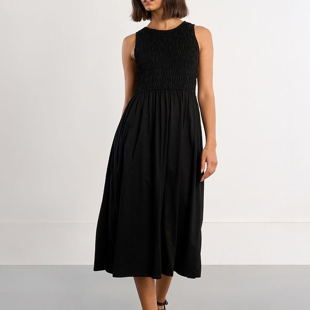 Woman wearing a black sleeveless dress against a white background
