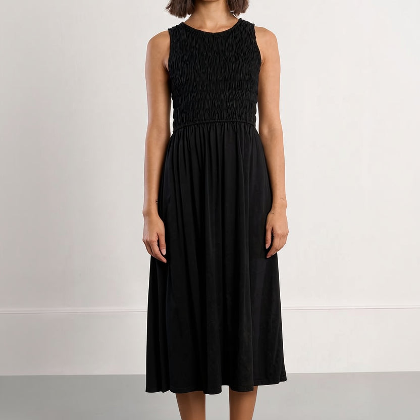 Woman wearing a black sleeveless dress with a plain background