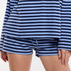 Woman wearing a blue and navy striped long-sleeve top and shorts 