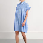 Woman wearing a blue striped dress on a white background