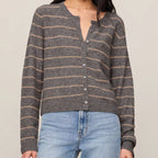 Woman wearing a striped sweater and jeans against a plain background