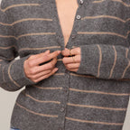 Woman wearing a gray striped cardigan against a neutral background