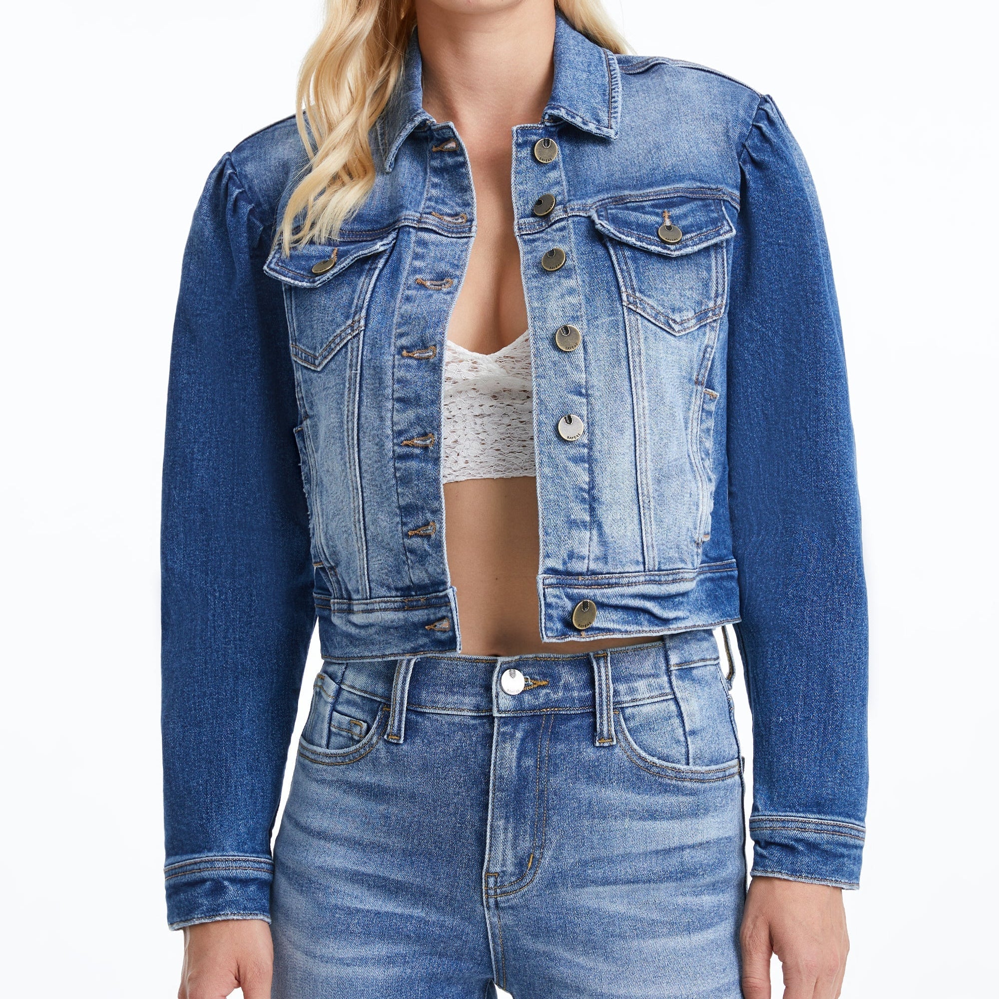 Woman wearing cropped blue denim jacket with puff sleeves and button front over white crop top and light denim jeans Main image