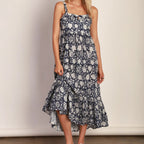 Woman wearing Emma Dress, navy blue floral print midi dress with spaghetti straps and asymmetrical hemline