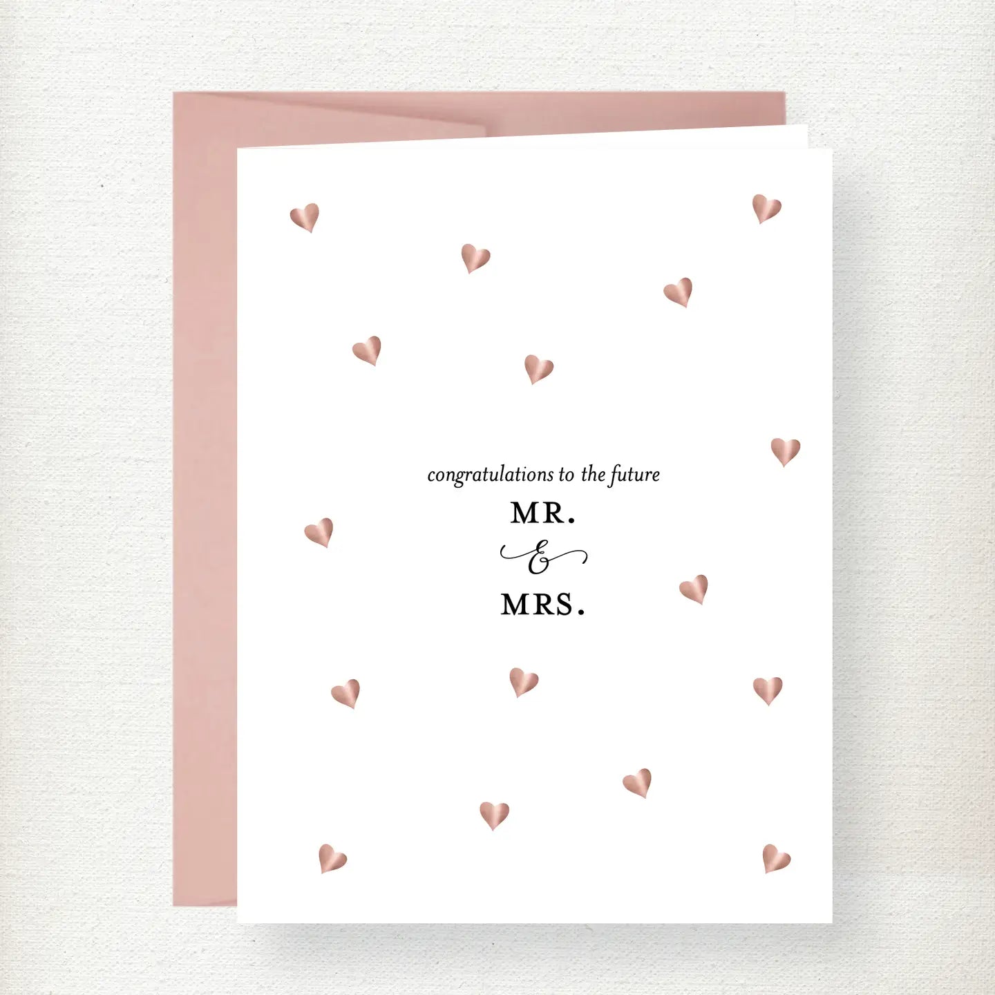 Wedding congratulations greeting card with rose gold foil hearts and Mr. and Mrs. text on white cardstock with pink envelope
