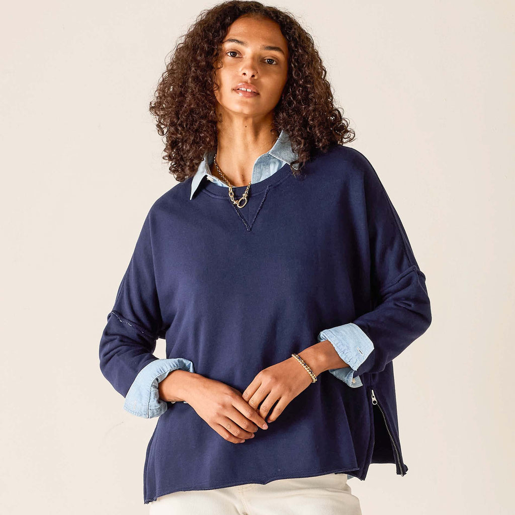 Woman wearing navy Frenchie Zip Size Crewneck sweatshirt with light denim collar and cuffs, styled with gold chain necklace