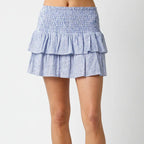 Gracelyn Linen Mini Skirt with tiered ruffled layers in blue and white vertical stripes, featuring smocked waistband