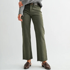 Woman wearing a gray sweater and green pants on a white background