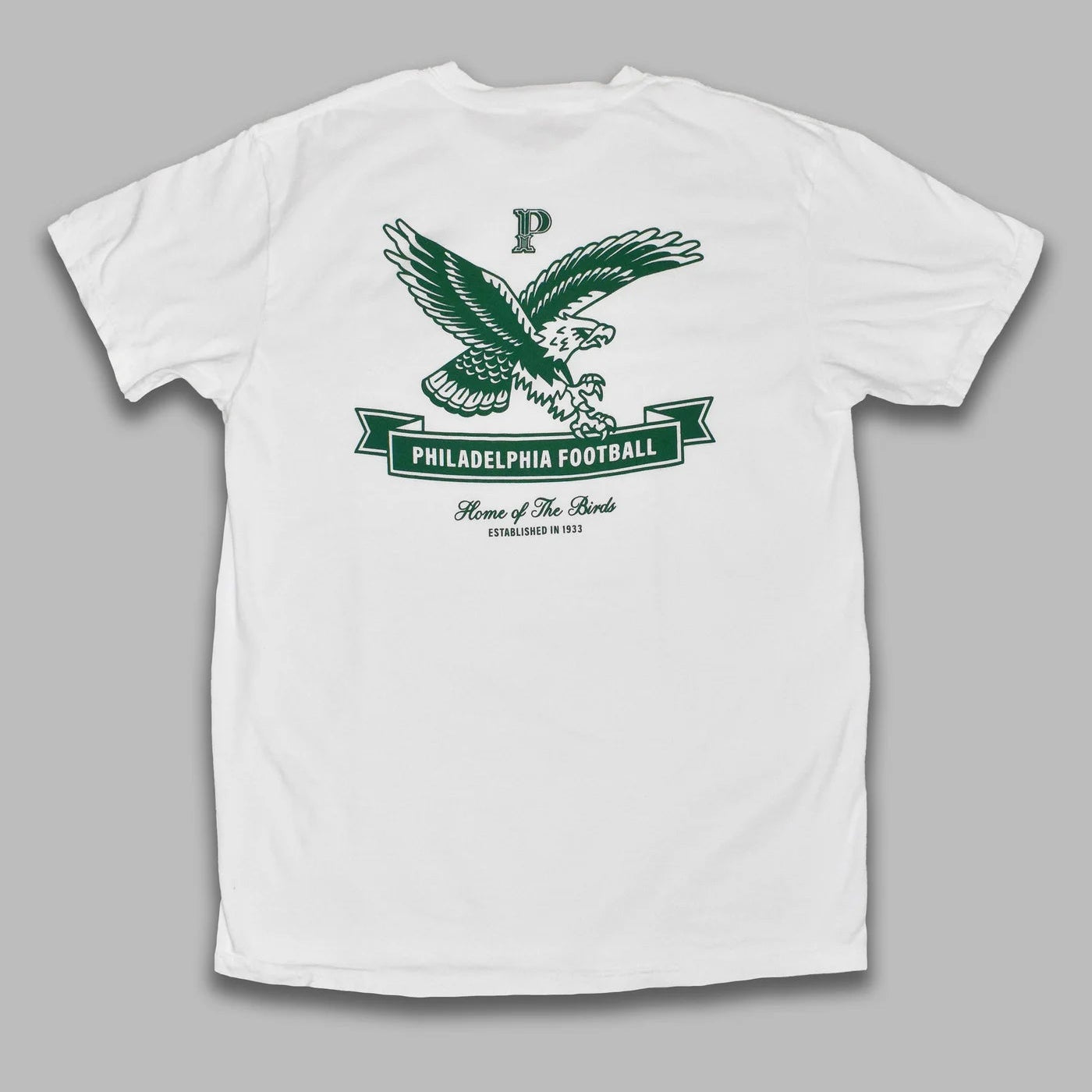 White t-shirt with green eagle graphic and text on a gray background