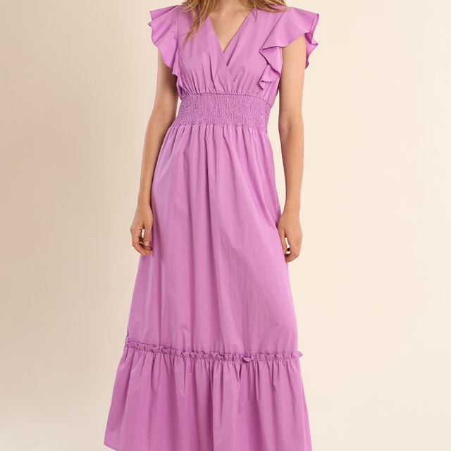 Woman wearing a purple dress against a beige background Main image