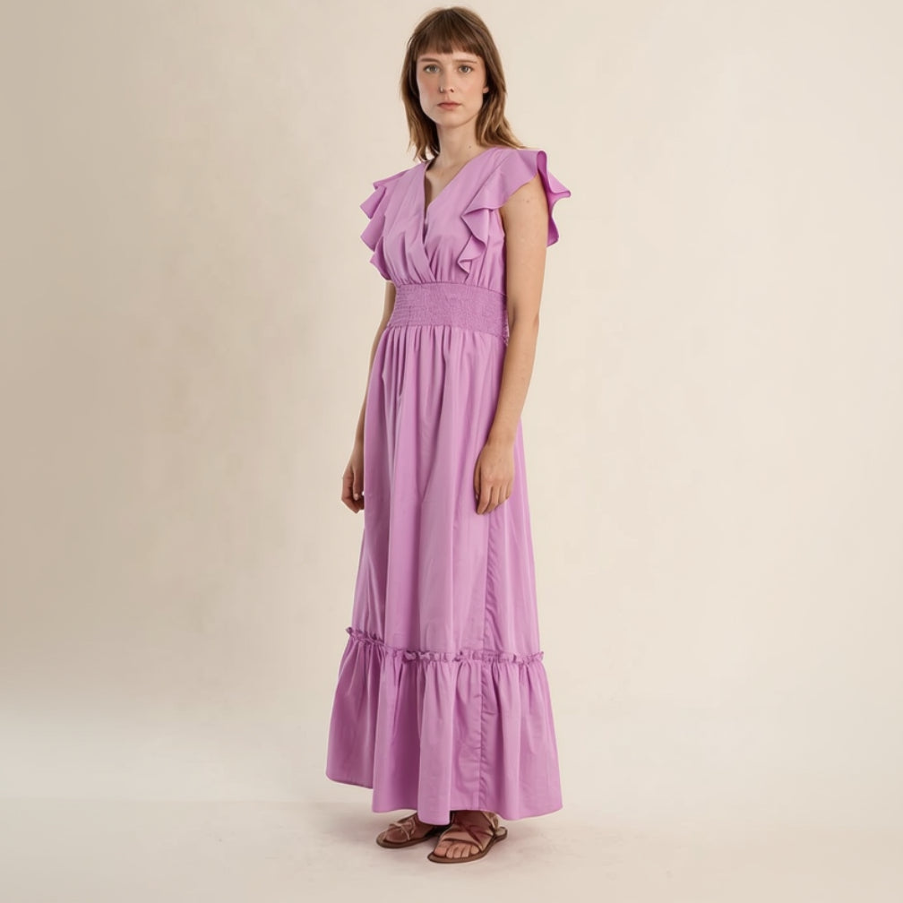 Woman wearing a purple dress with ruffled sleeves on a beige background
