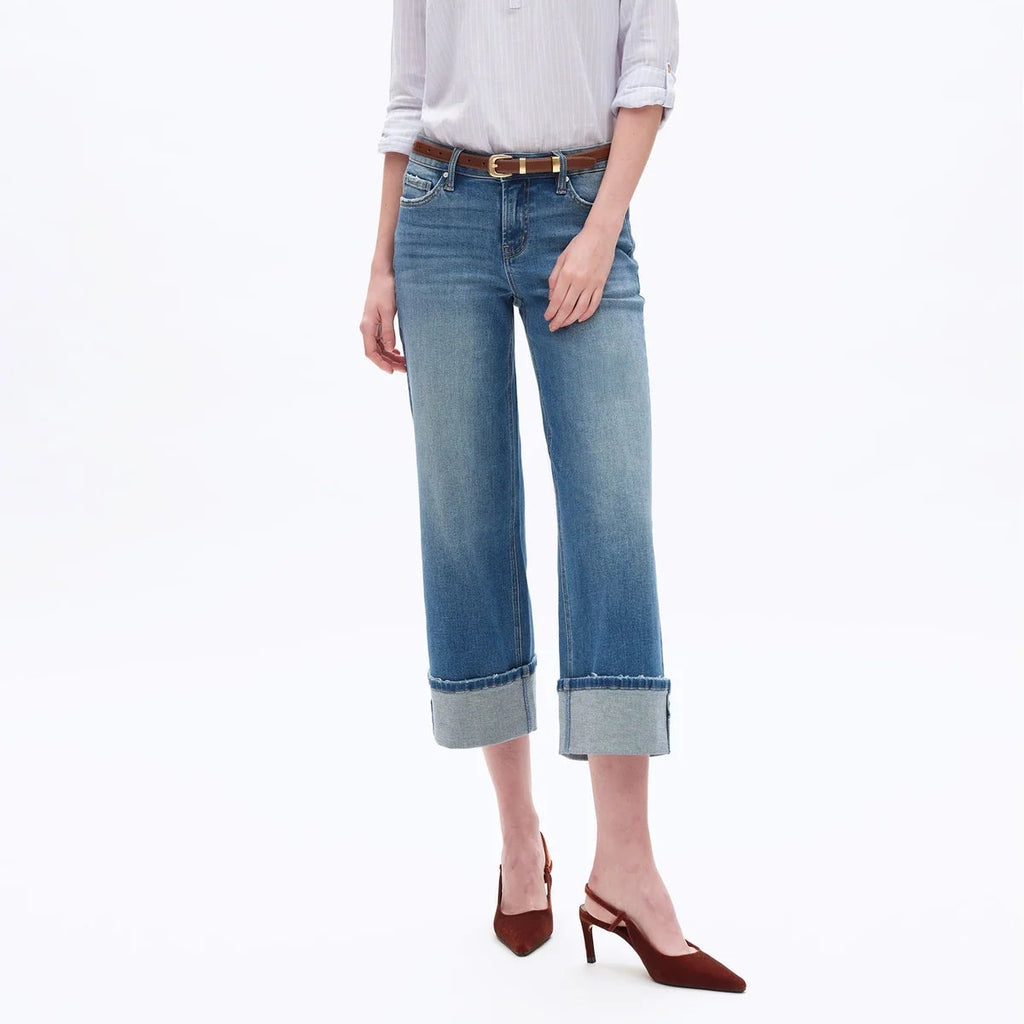 Woman wearing light purple button-up shirt, brown belt, and low rise straight leg crop jeans with rolled cuffs and burgundy …
