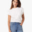 Woman wearing a white t-shirt and blue jeans on a white background