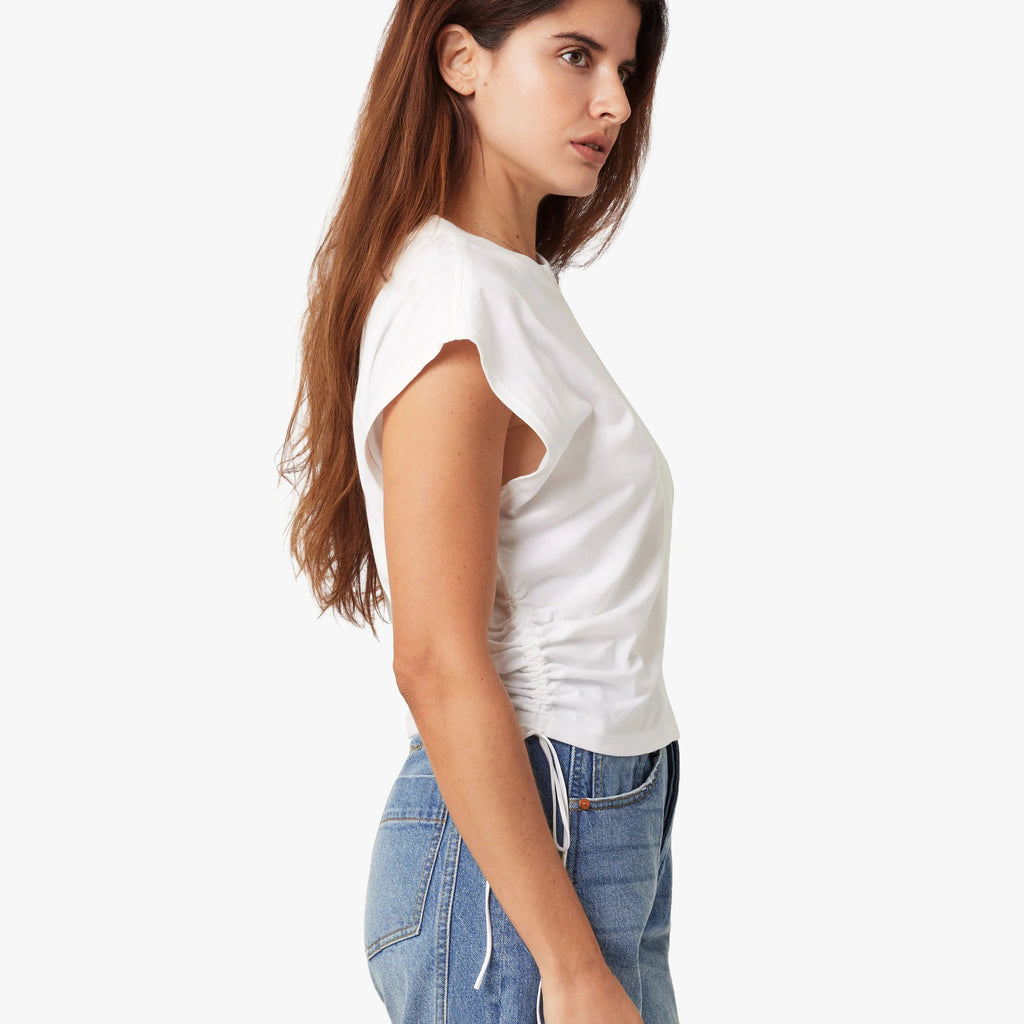 Woman wearing a white top and blue jeans on a white background