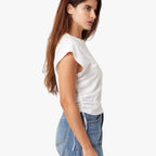 Woman wearing a white top and blue jeans on a white background