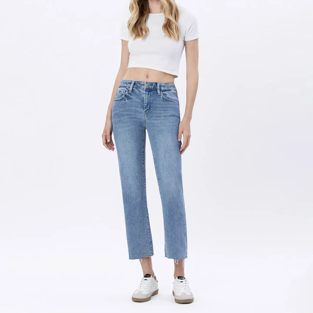 Woman wearing white cropped t-shirt and light blue mid-rise straight jeans with white platform sneakers