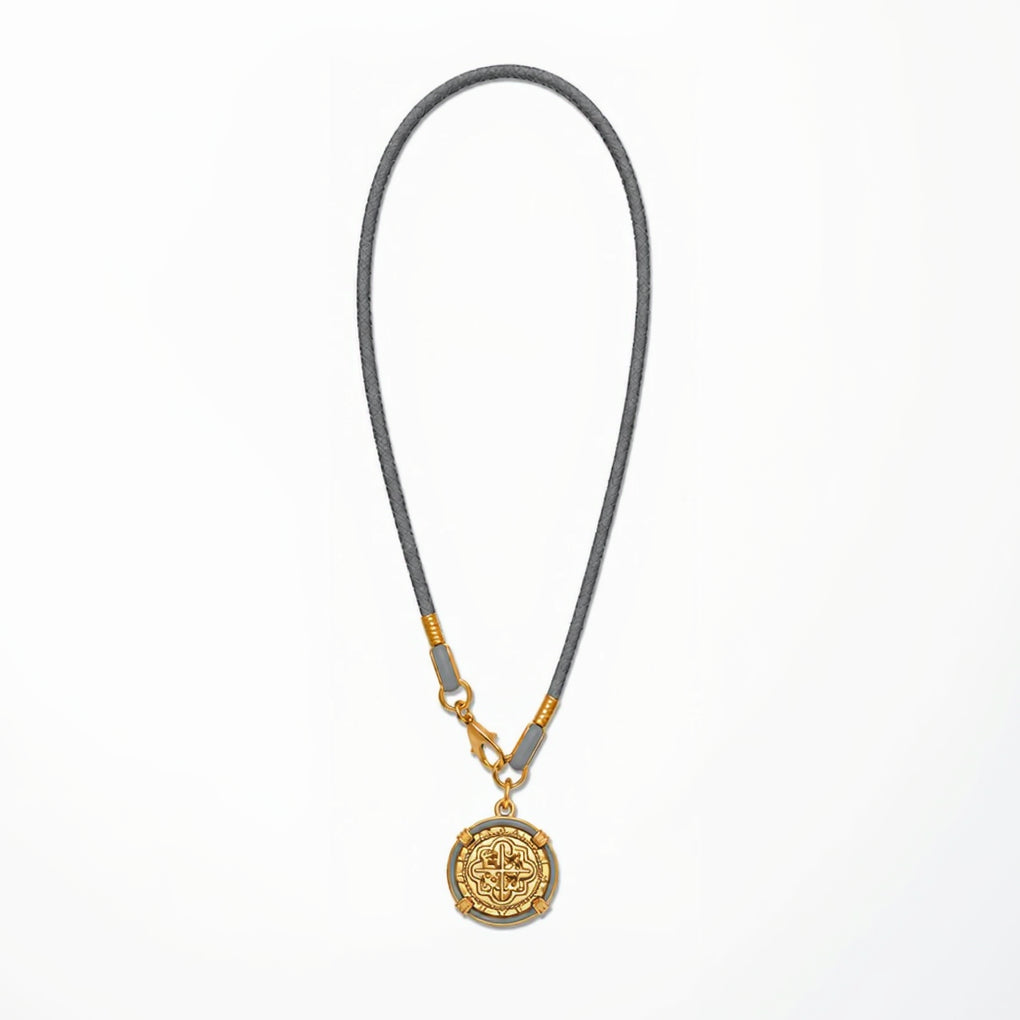 Necklace with a gold pendant on a gray cord against a white background
