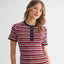 Woman wearing Parker Striped Top with multicolor horizontal stripes in red, navy, white, and tan with navy button placket