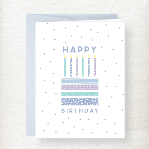 Happy Birthday greeting card featuring a colorful patterned cake with six lit candles and blue polka dot background