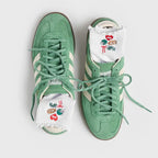 A pair of mint green low-top sneakers with white socks peeking out from the toes, photographed from above on a light gray background.