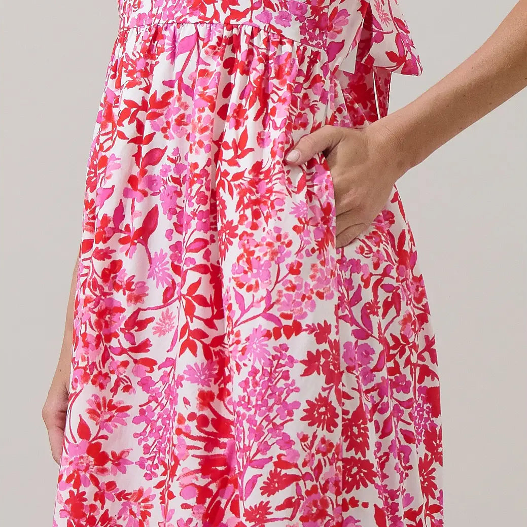 Woman wearing Reidy Floral Mawar Ruffle Midi dress with pink and red floral print on white background, hand on hip Main image