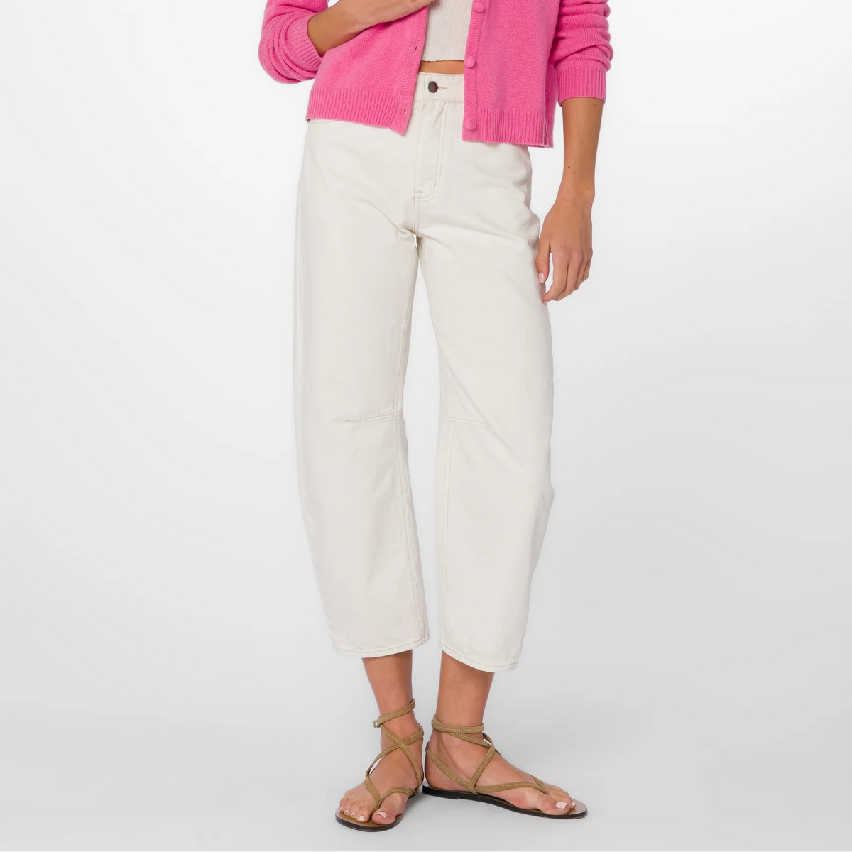 Woman wearing cream barrel crop jeans with pink cardigan and olive strappy sandals