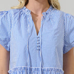 Woman wearing blue and white striped empire waist mini dress with short puffed sleeves and tiered ruffle hem