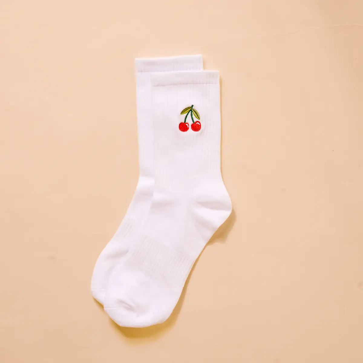 White crew socks with embroidered red cherries and green stems on the upper foot