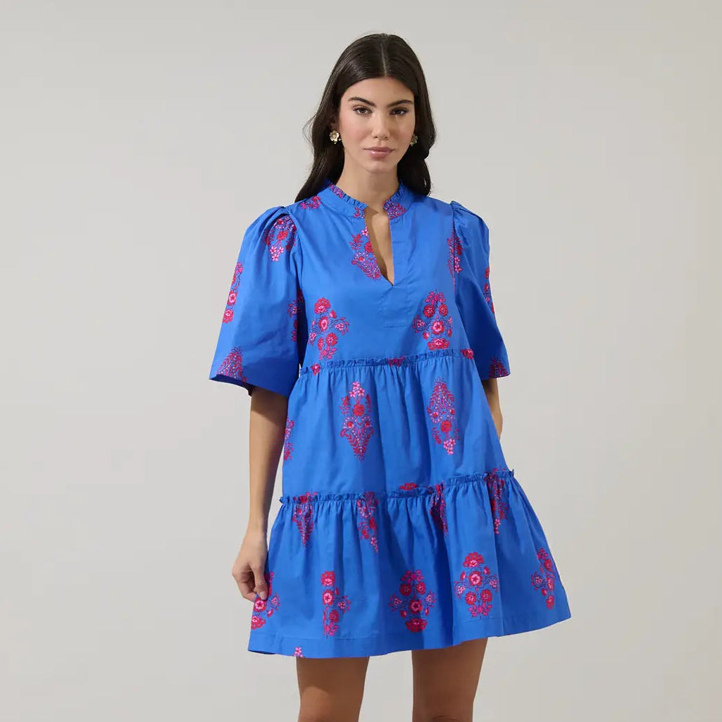 Woman wearing blue Shayna Floral Dixie Split Neck Shift Dress with red floral embroidery and tiered skirt Main image