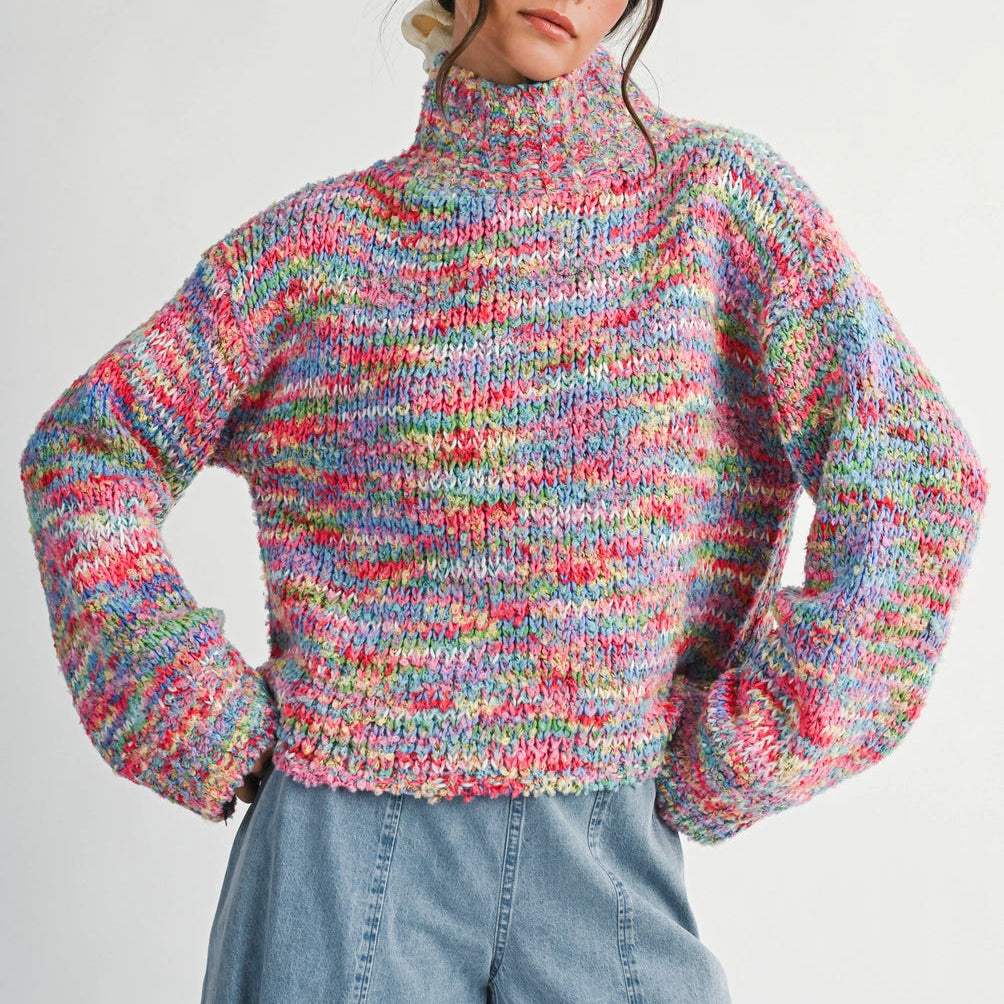 Woman wearing a colorful knitted sweater and blue jeans on a white background