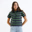 Woman wearing navy and neon green striped short sleeve collared cardigan sweater with light blue jeans