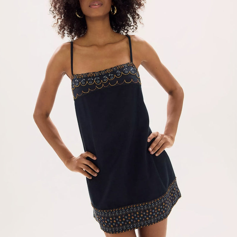 Woman wearing a black slip dress with lace and bead details on a white background Main image