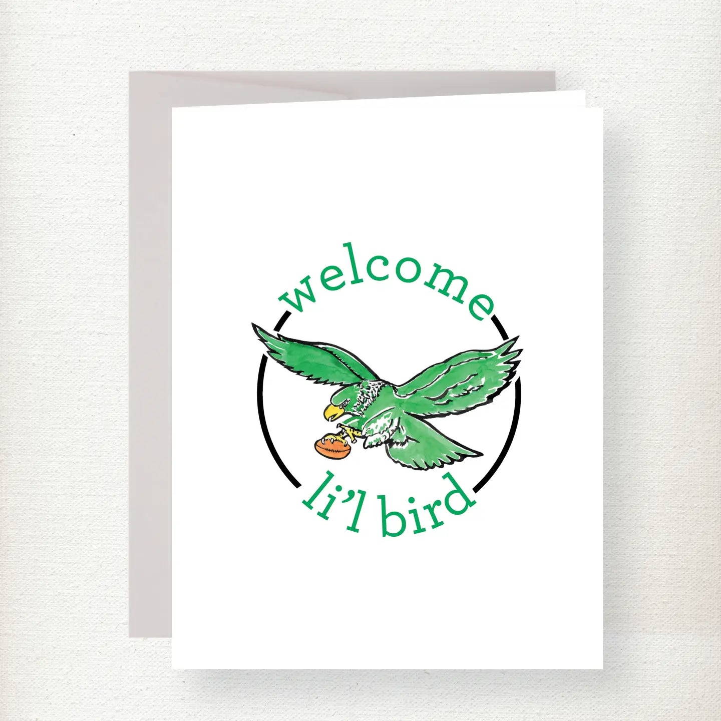 Green eagle in flight holding a football with welcome text curved around it in a circular design