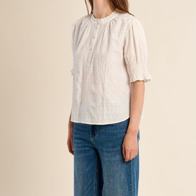 Woman wearing a white blouse and blue jeans on a beige background