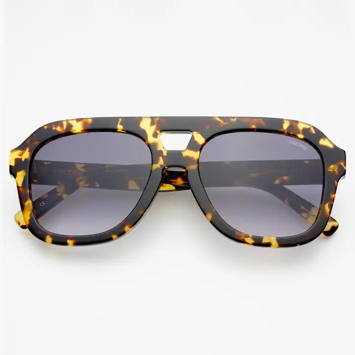 Yellow tortoise sunglasses against a white background. 